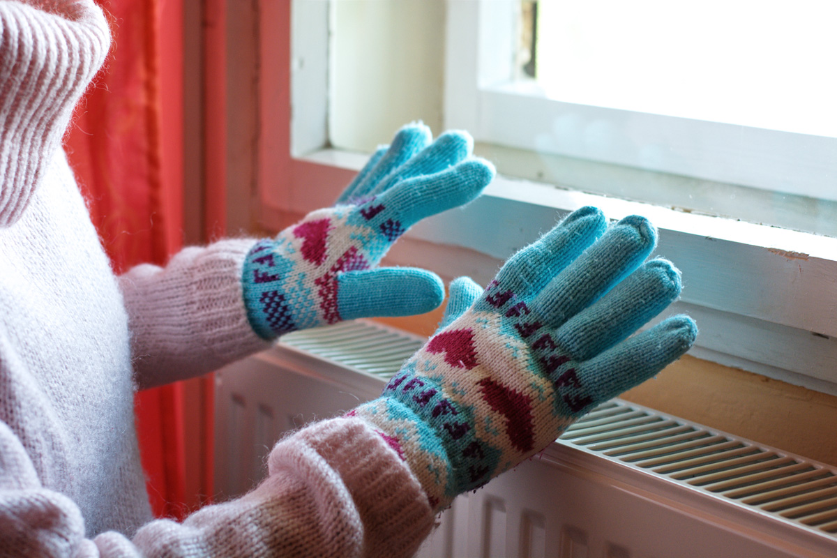 picture of gloved hands being warmed over a heater